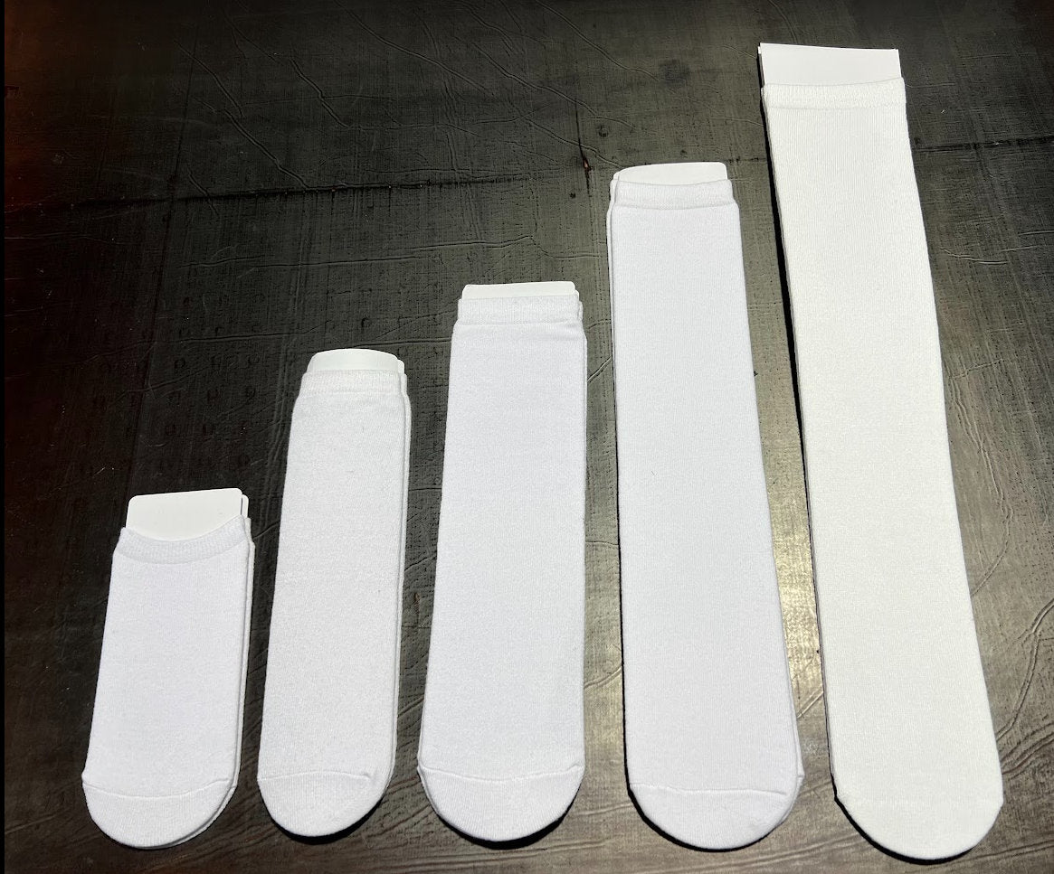 three pairs of white socks sitting on top of a wooden floor
